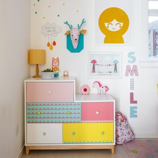 Kids bedroom with patterned chest of drawers with decorated wall