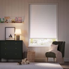 Grey blackout blind in white kids room with black chest of drawers