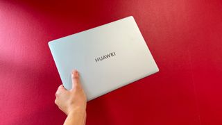 The closed Huawei MateBook 14 Ultra Pro against a red wall.