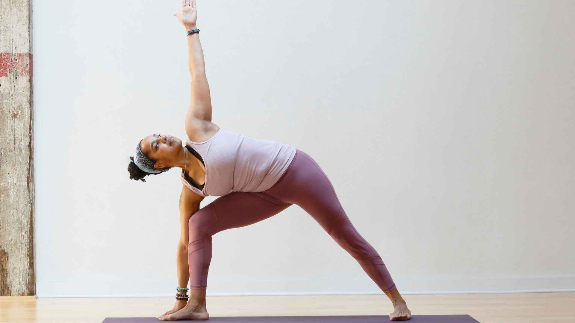 Žena cvičící jógu ve studiu, což představuje jeden způsob, jak snížit hladinu kortizolu prostřednictvím cvičení