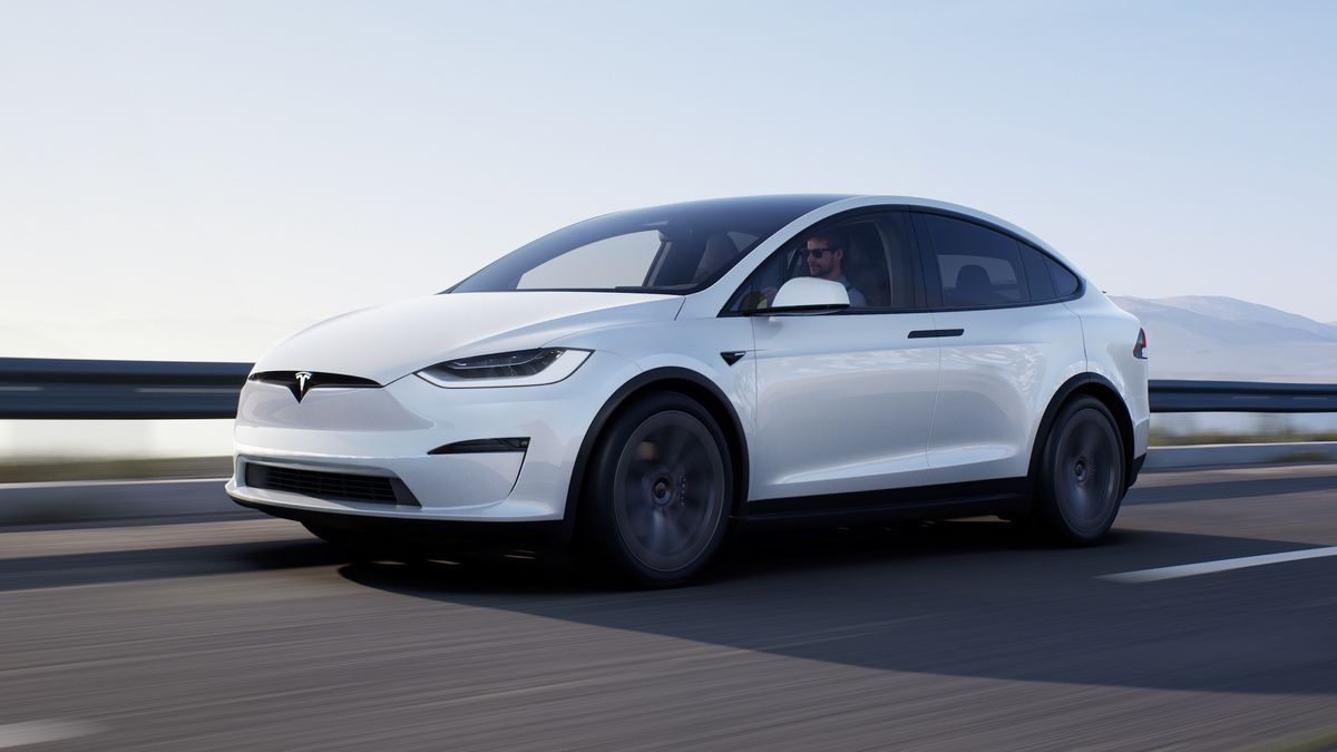 A white Tesla Model X driving on a road