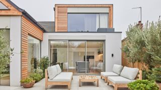modern rendered house with loft conversion featuring timber clad front and large windows