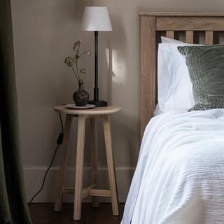 Wooden round side table in bedroom