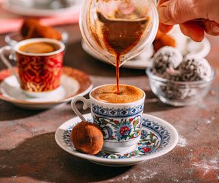 An ornate coffee cup being filled with Turkish coffee