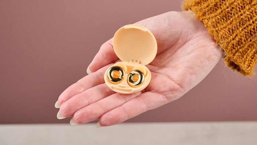 A woman is holding the Loop Switch 2 earplugs in their case in her outstretched hand.