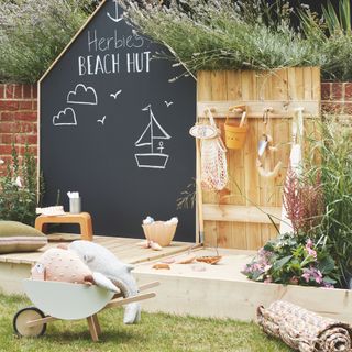 small garden with chalkboard area, kids play area, toys, decking, sandpit
