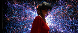 Woman wearing VR headset against light display background
