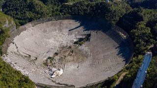 An aerial view of the massive radio dish at Arecibo Observatory after the telescope's collapse.