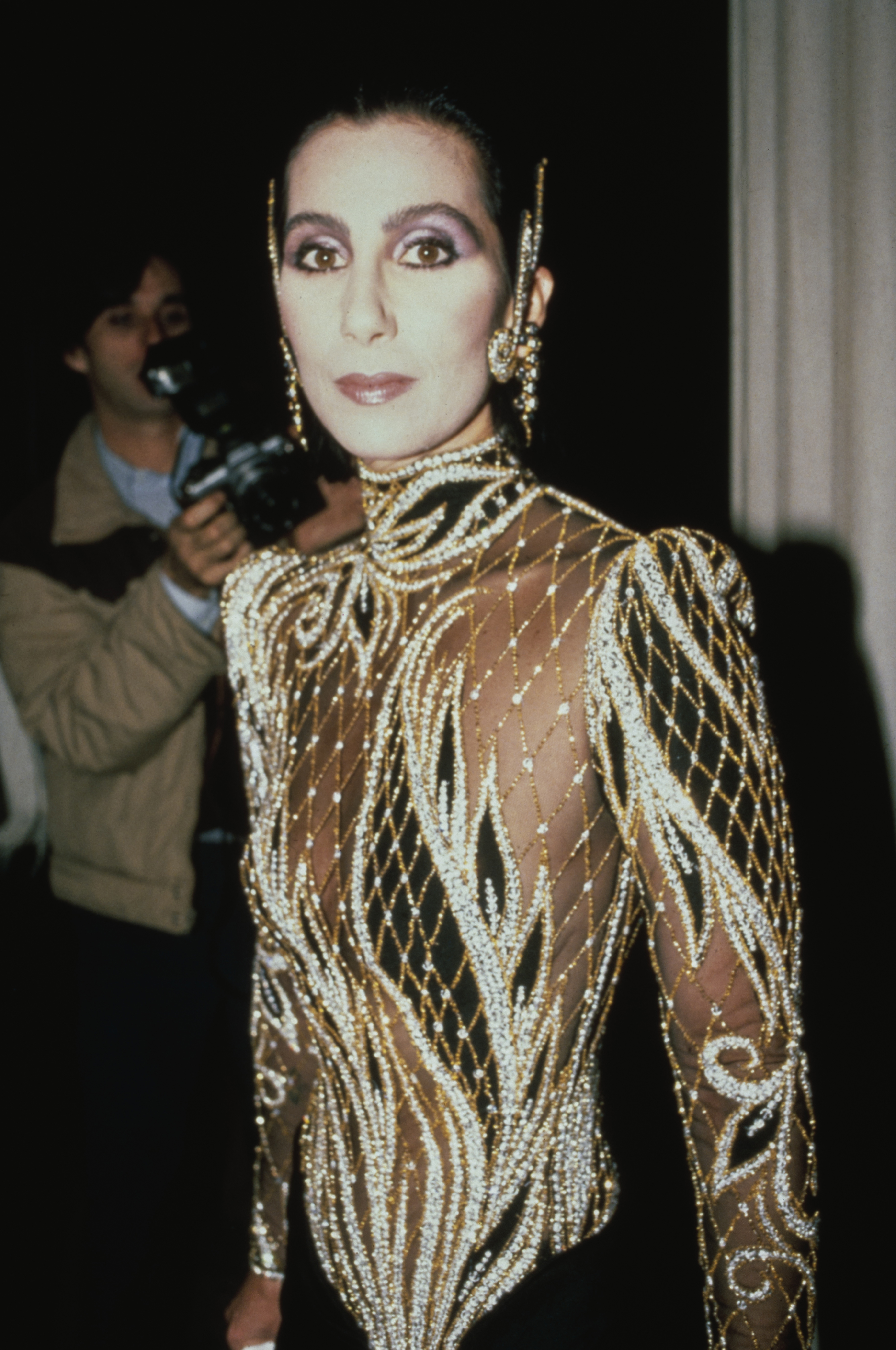 Cher wears a custom sequin black and sheer outfit by Bob Mackie at the Met Gala exhibition of "Costumes of Royal India" in New York City, United States, 9th December 1985.