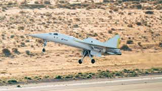 un aereo bianco e argento dal muso a spillo atterra su una pista di atterraggio nel deserto