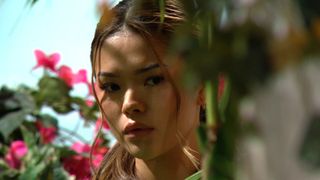 Luna (Lisa Yamada) peers out from behind a bush in The Bold and the Beautiful