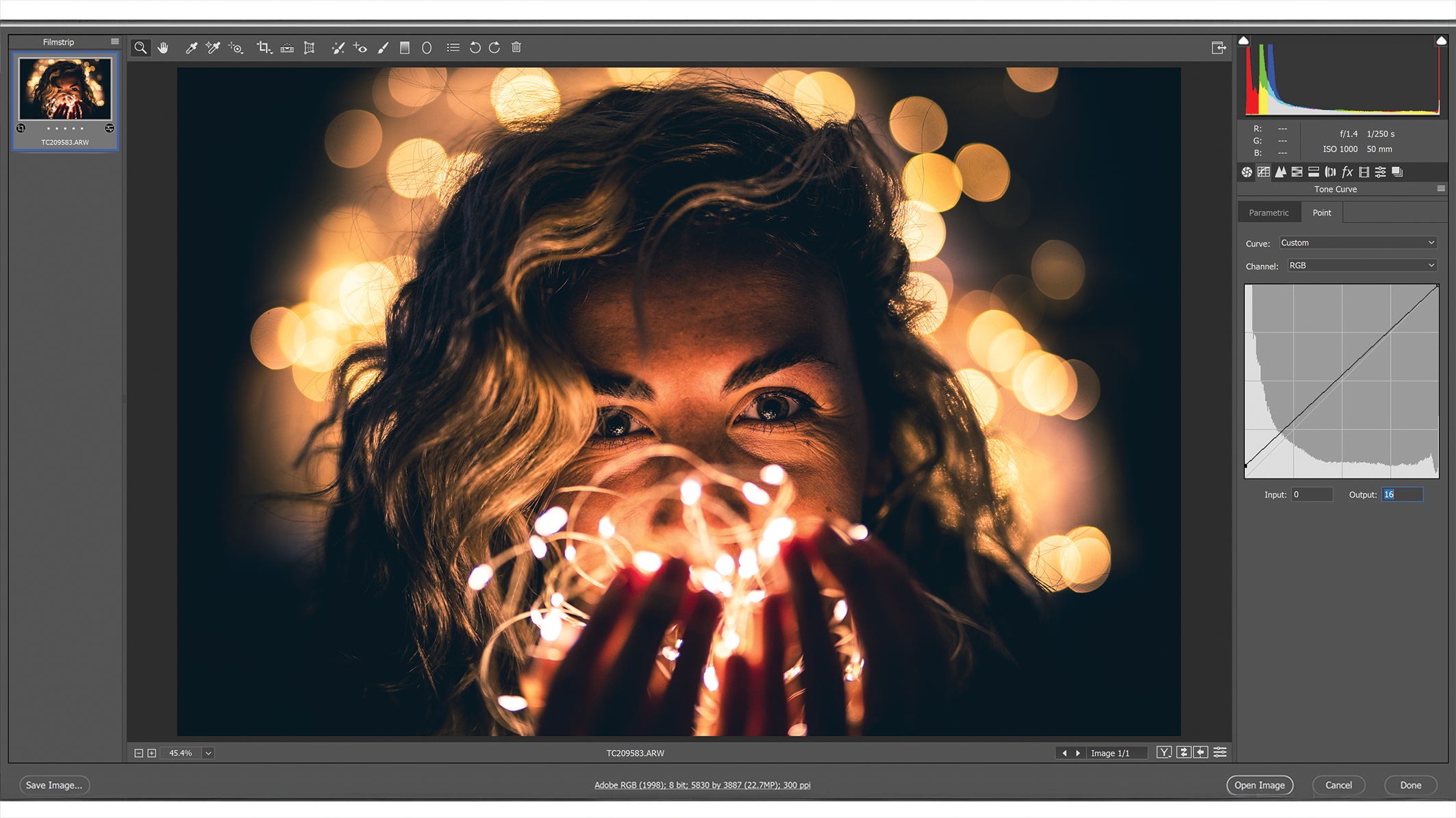 A Photoshop window with editing menus, an image in the center showing a person with wavy hair surrounded by soft, golden bokeh lights that create a warm and dreamy atmosphere