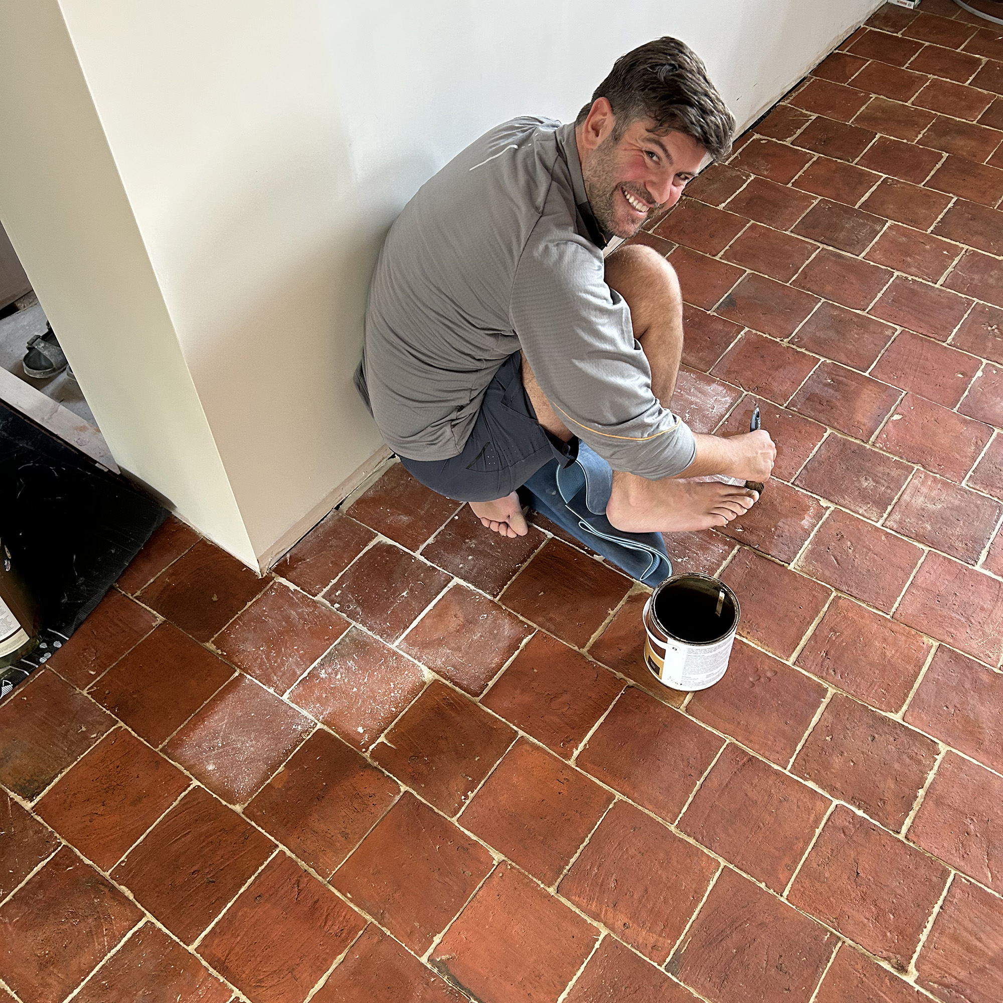 a man waxing a terracotta brick floor