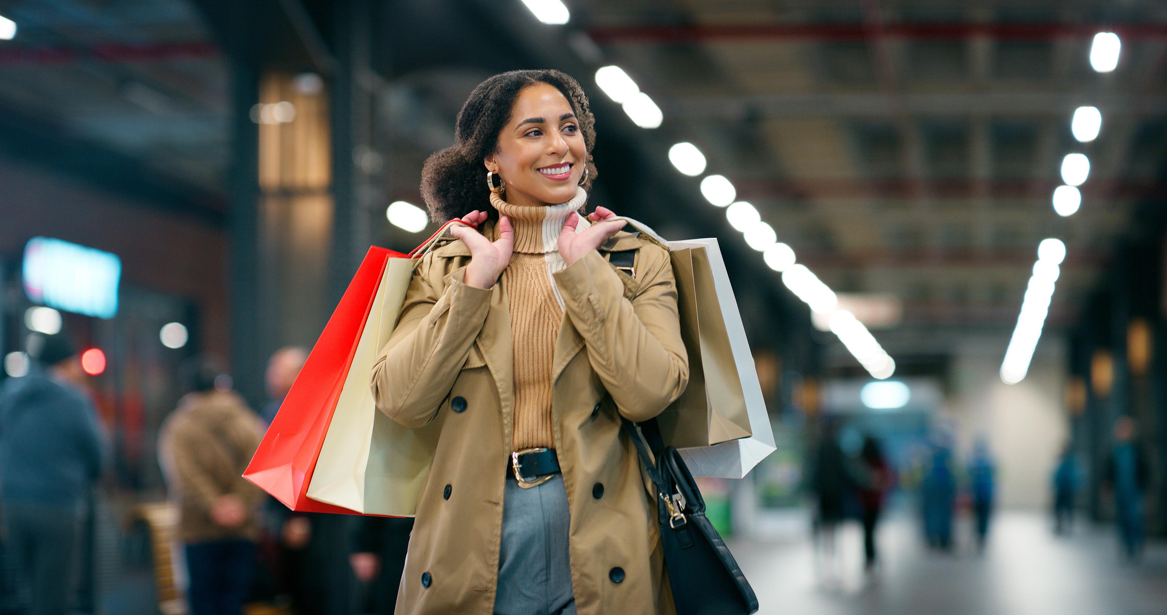  A happy woman carrying shopping bags over her shoulder. 
