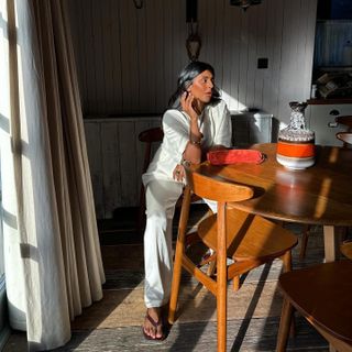 Monikh sitting at a farmhouse table with glowing skin.