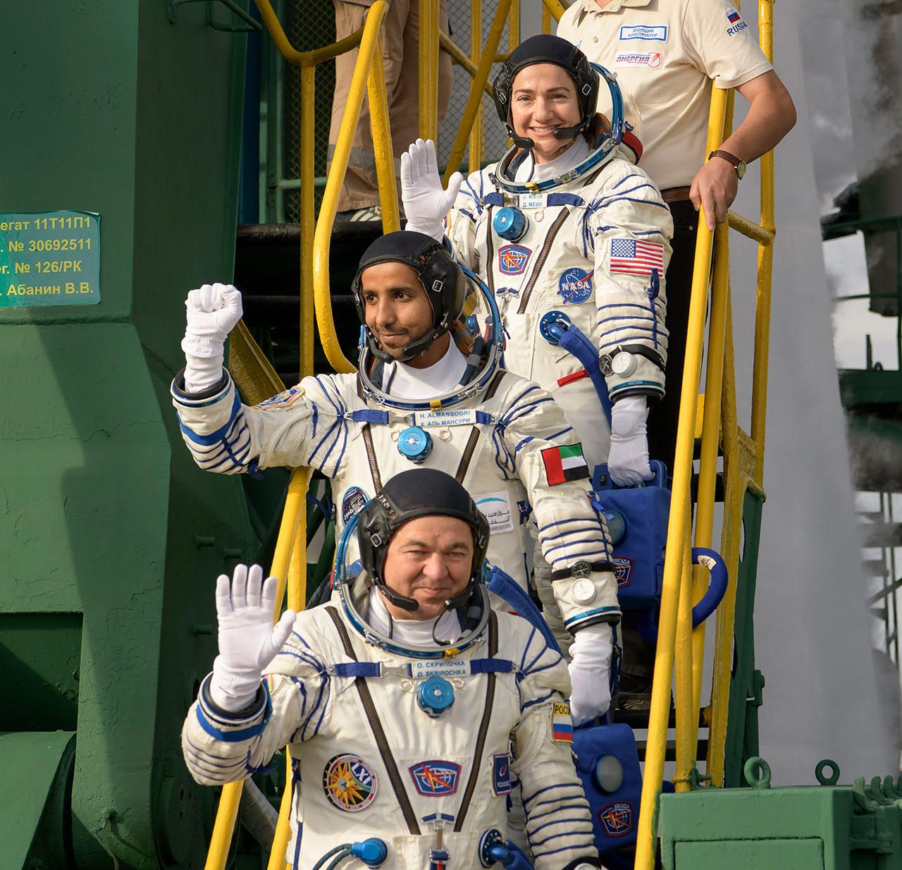 Soyuz MS-15 crew members Oleg Skripochka, Hazzaa AlMansoori and Jessica Meir wave from the base of their Soyuz-FG rocket prior to boarding the vehicle at the Baikonur Cosmodrome in Kazakhstan on Wednesday, Sept. 25, 2019.
