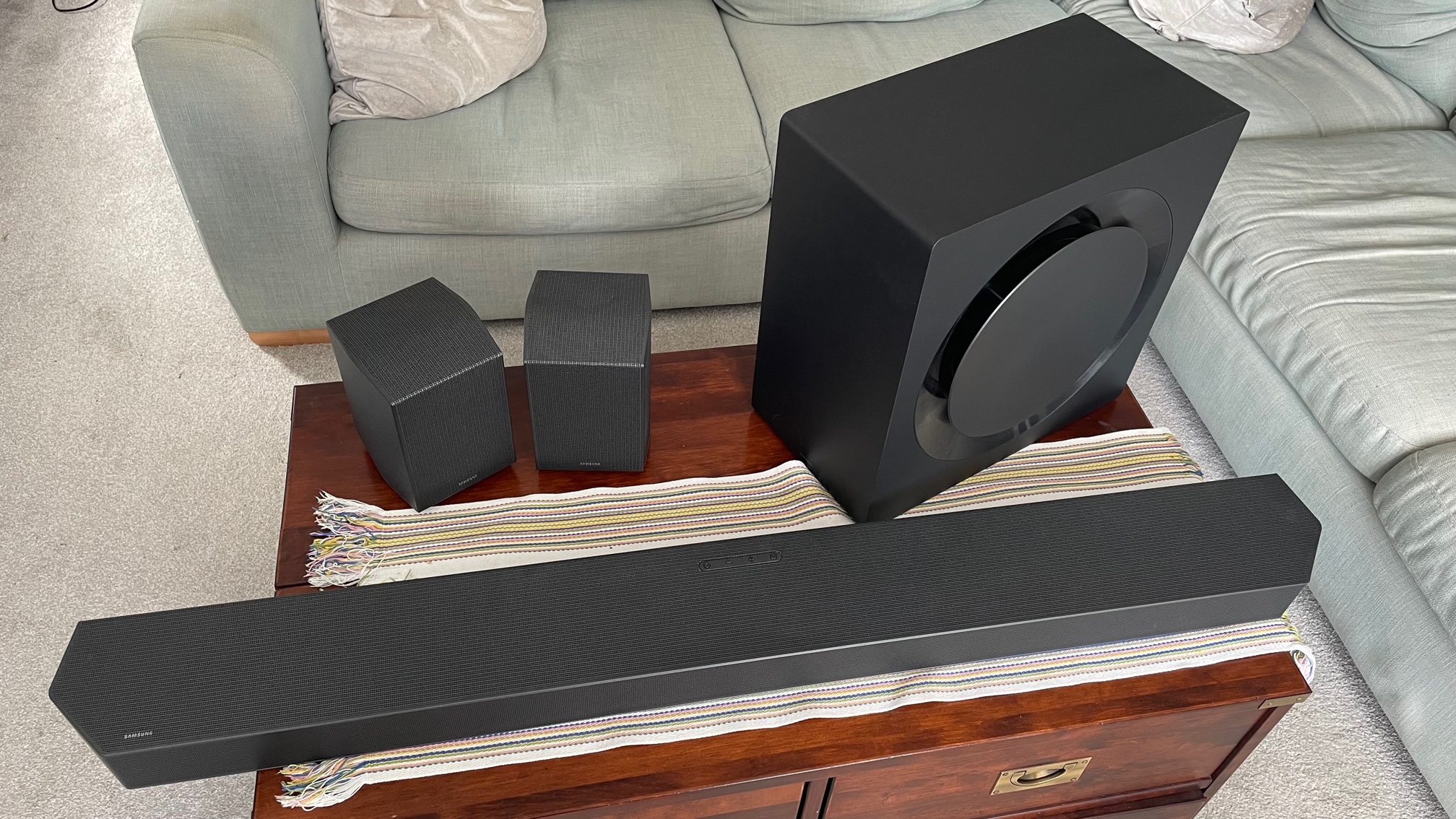 The Samsung HW-Q990C soundbar system pictured in a living room on a wooden table