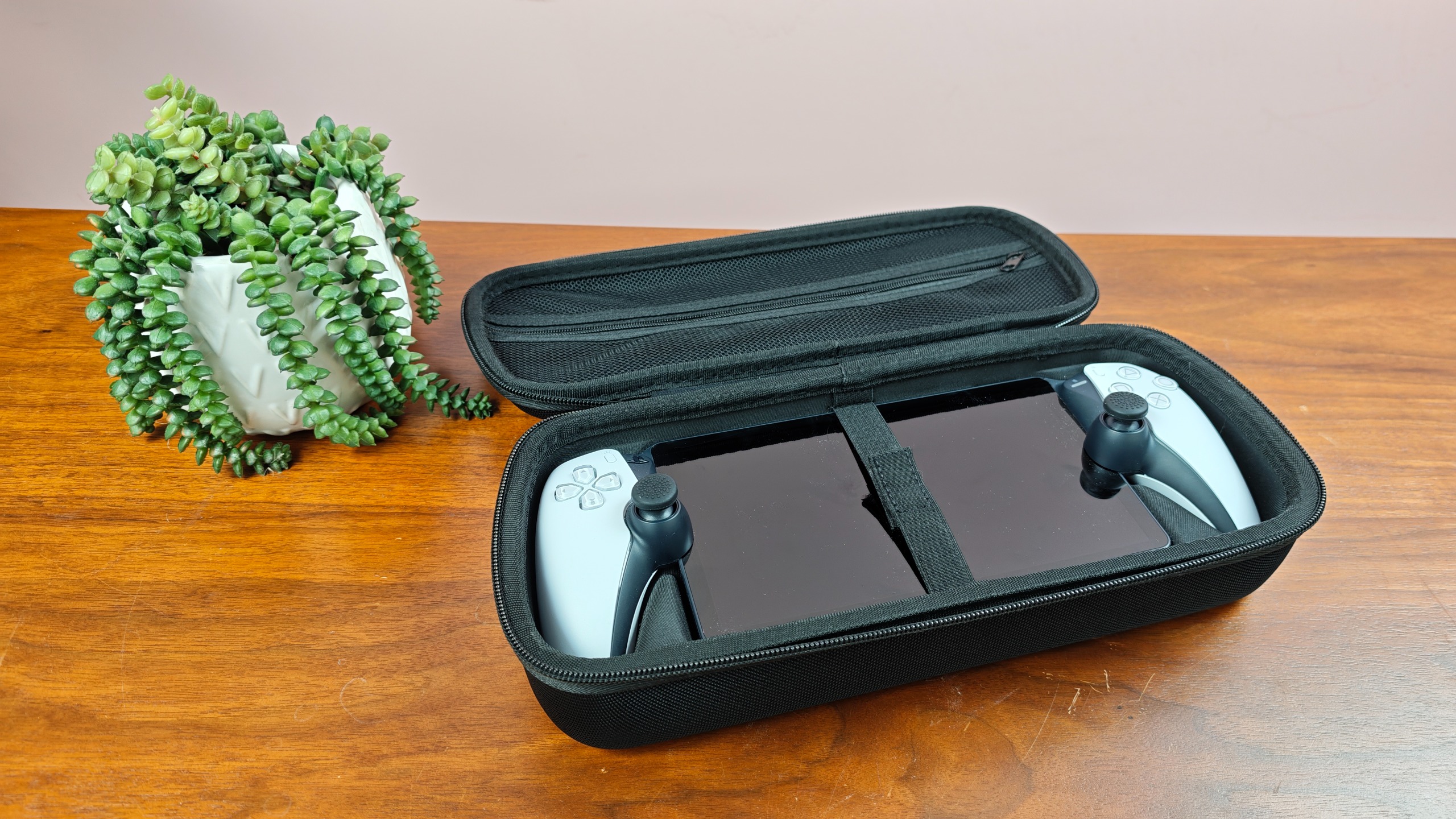 Venom PlayStation Portal Carry Case with PS Portal and plant on table