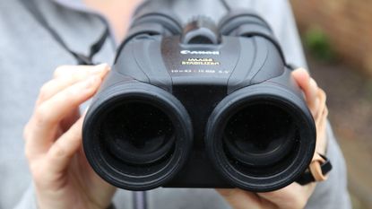 Woman holding a pair of Canon 10x42L IS WP binoculars