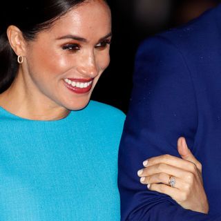 Meghan Markle holding Prince Harry's arm with a striking nude manicure