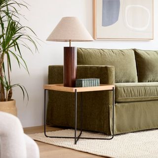 West Elm metal and wood side table with metal legs and white wooden tray top styled with a lamp and ridged green trinket box