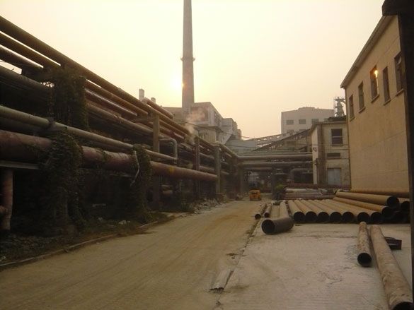 A striking cluster of disused boiler towers, railroad tracks and chimneys