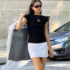 woman in white mini skirt and black top