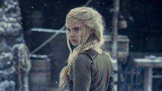 Ciri in The Witcher season 2, standing outside in the snow, looking over her shoulder.