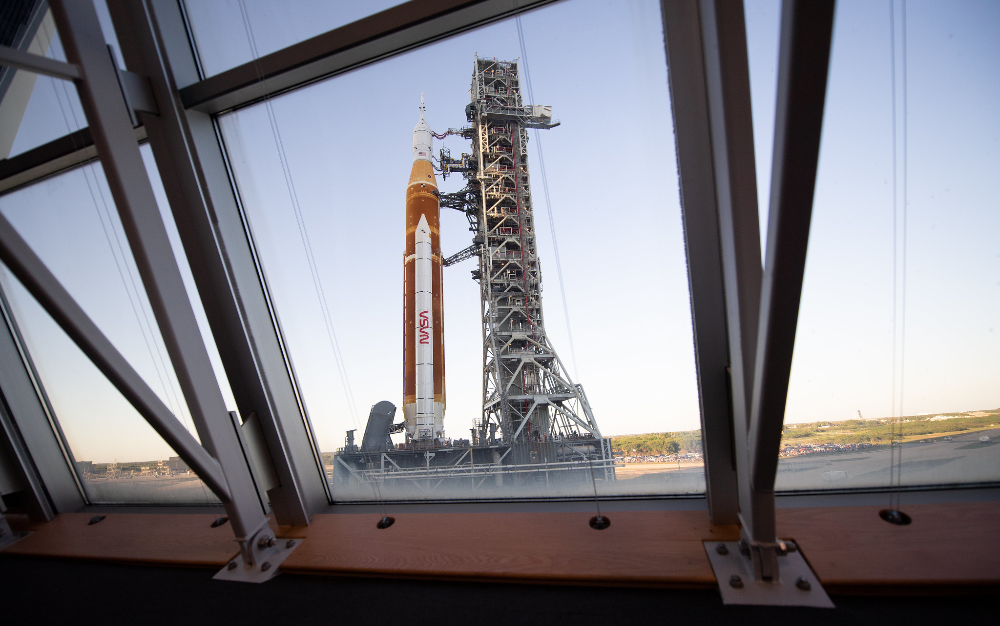 NASA’s Space Launch System (SLS) rocket with the Orion spacecraft aboard is seen through the windows of Firing Room One in the Rocco A. Petrone Launch Control Center atop a mobile launcher as it rolls out of High Bay 3 of the Vehicle Assembly Building for the first time to Launch Complex 39B, Thursday, March 17, 2022, at NASA’s Kennedy Space Center in Florida.