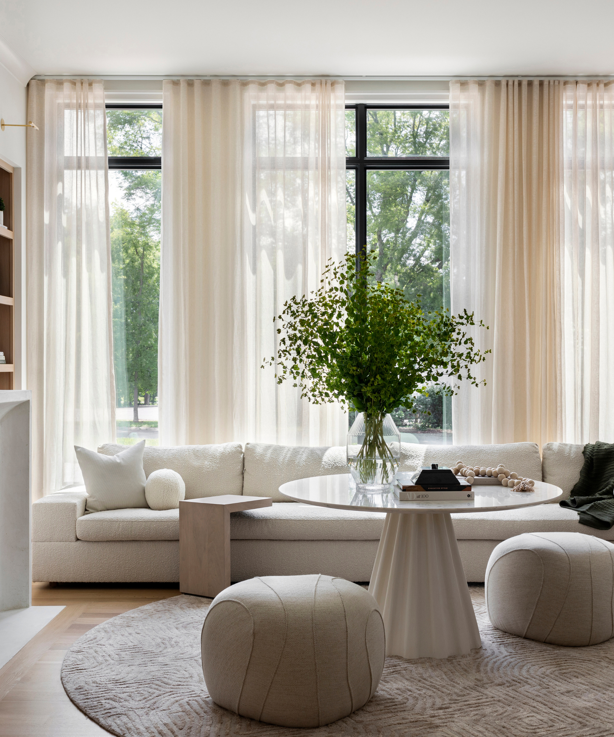 Light, bright dining room area featuring a circular ivory rug accented with an artistically carved high-low texture