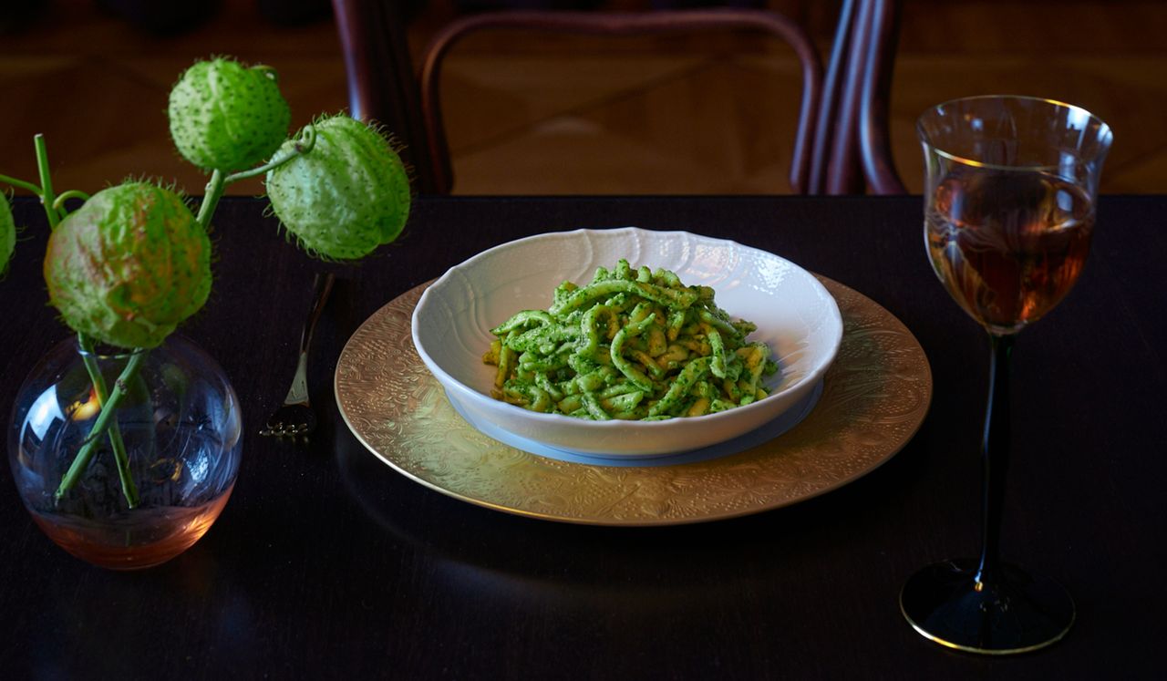 Rocket &amp; Walnut Pesto sits on a dark wooden table