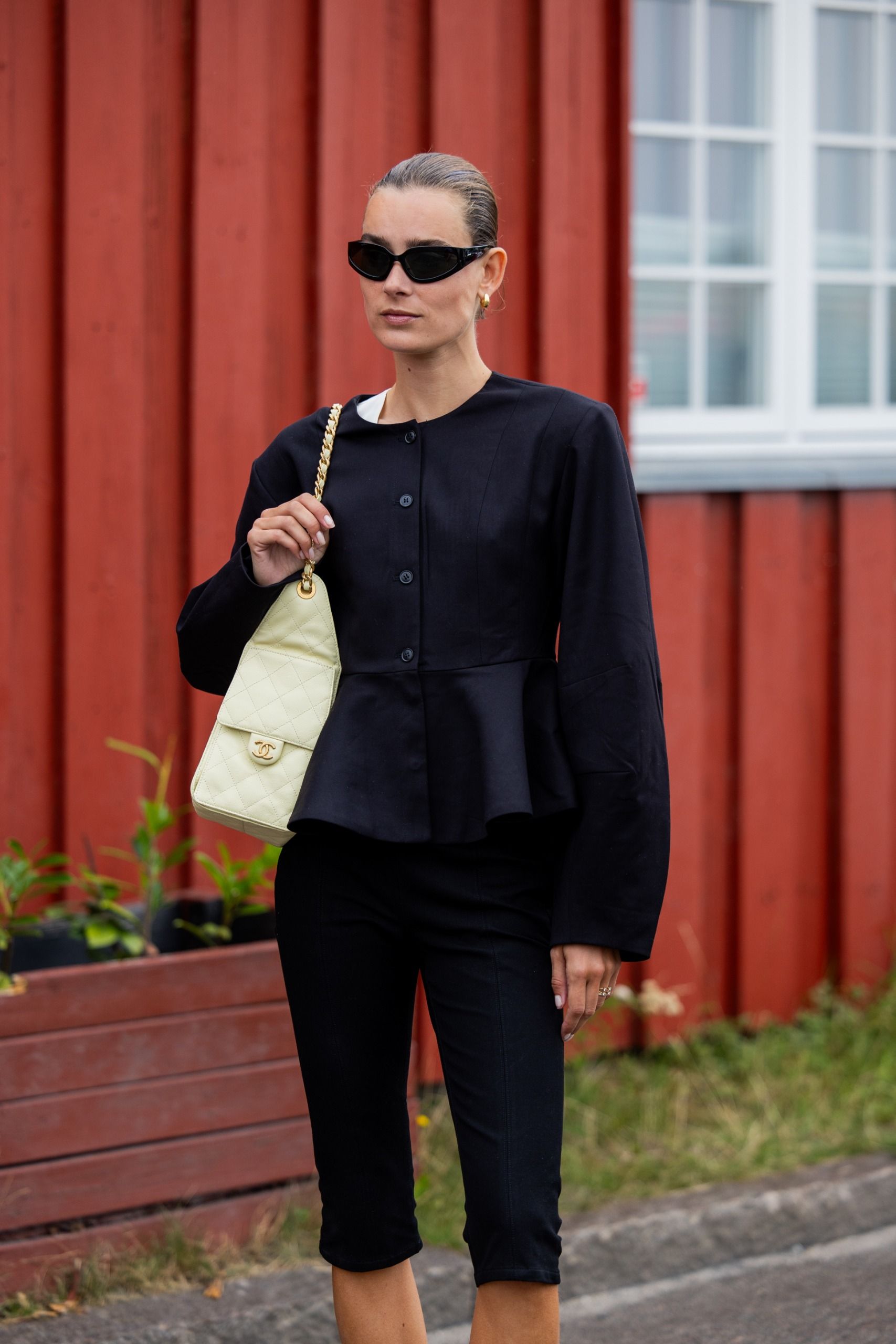 woman wears black collarless jacket and capri pants