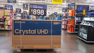 A Samsung TV box on the floor of a Walmart. It is strapped shut and ready to be moved.