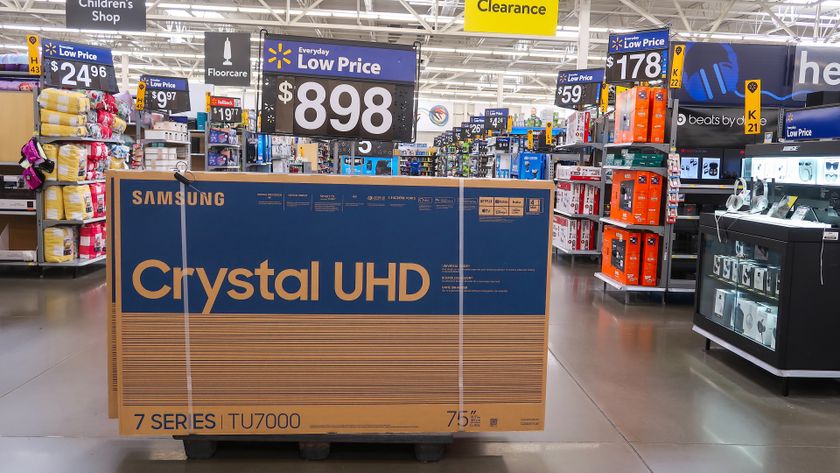 A Samsung TV box on the floor of a Walmart. It is strapped shut and ready to be moved.