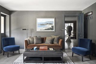 living room with grey walls and blue velvet chairs