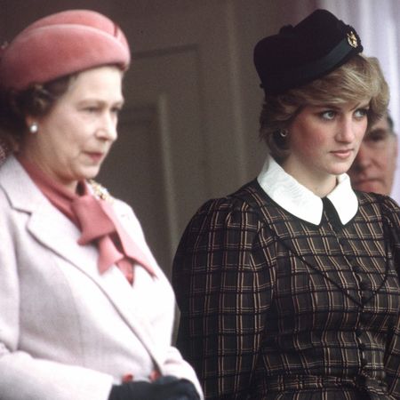 Princess Diana wears a tartan dress with a white collar and stands between Queen Elizabeth II, who wears a light pink coat, and King Charles