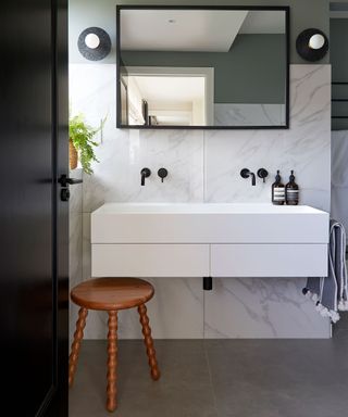 Cloakroom with large sink and marble backsplash