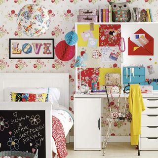girl's bedroom with floral wallpaper and study table