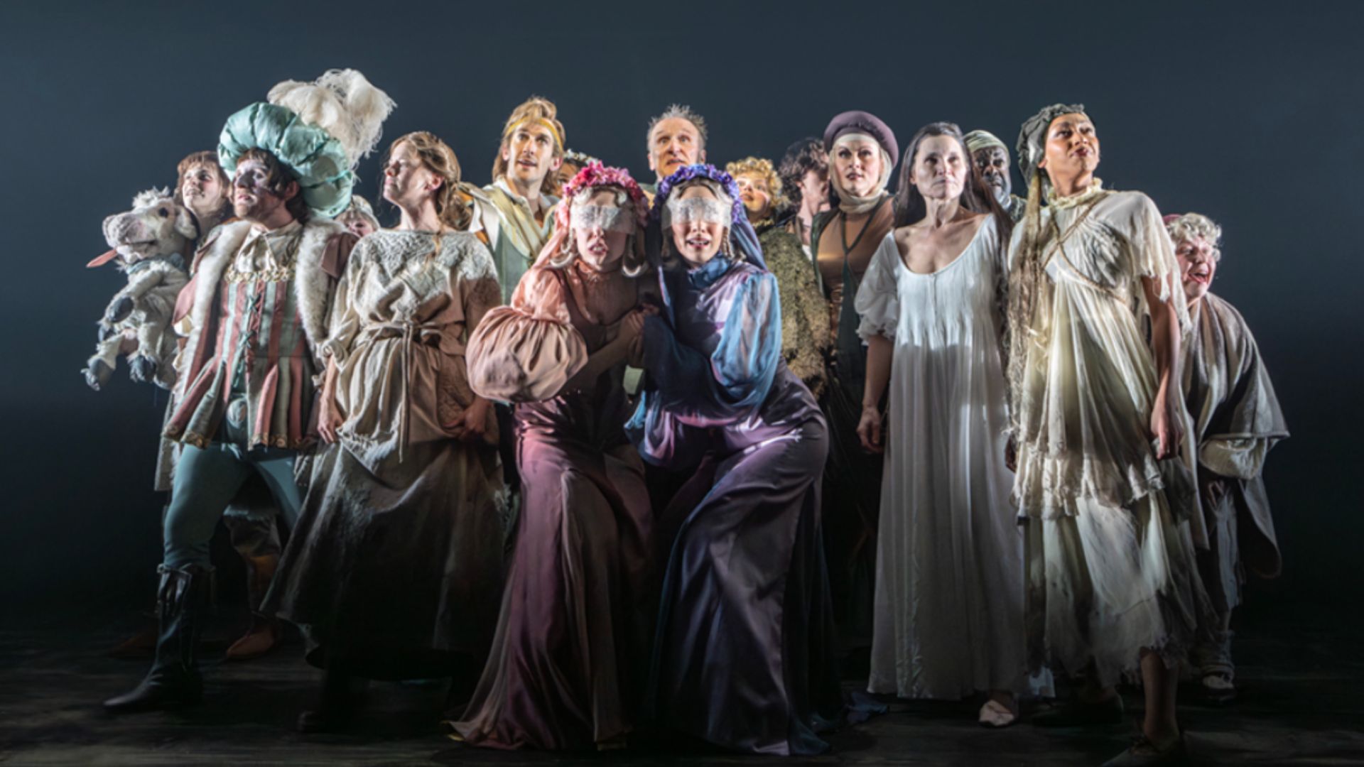 a production image from Into the Woods at Bridge Theatre showing the full cast ensemble