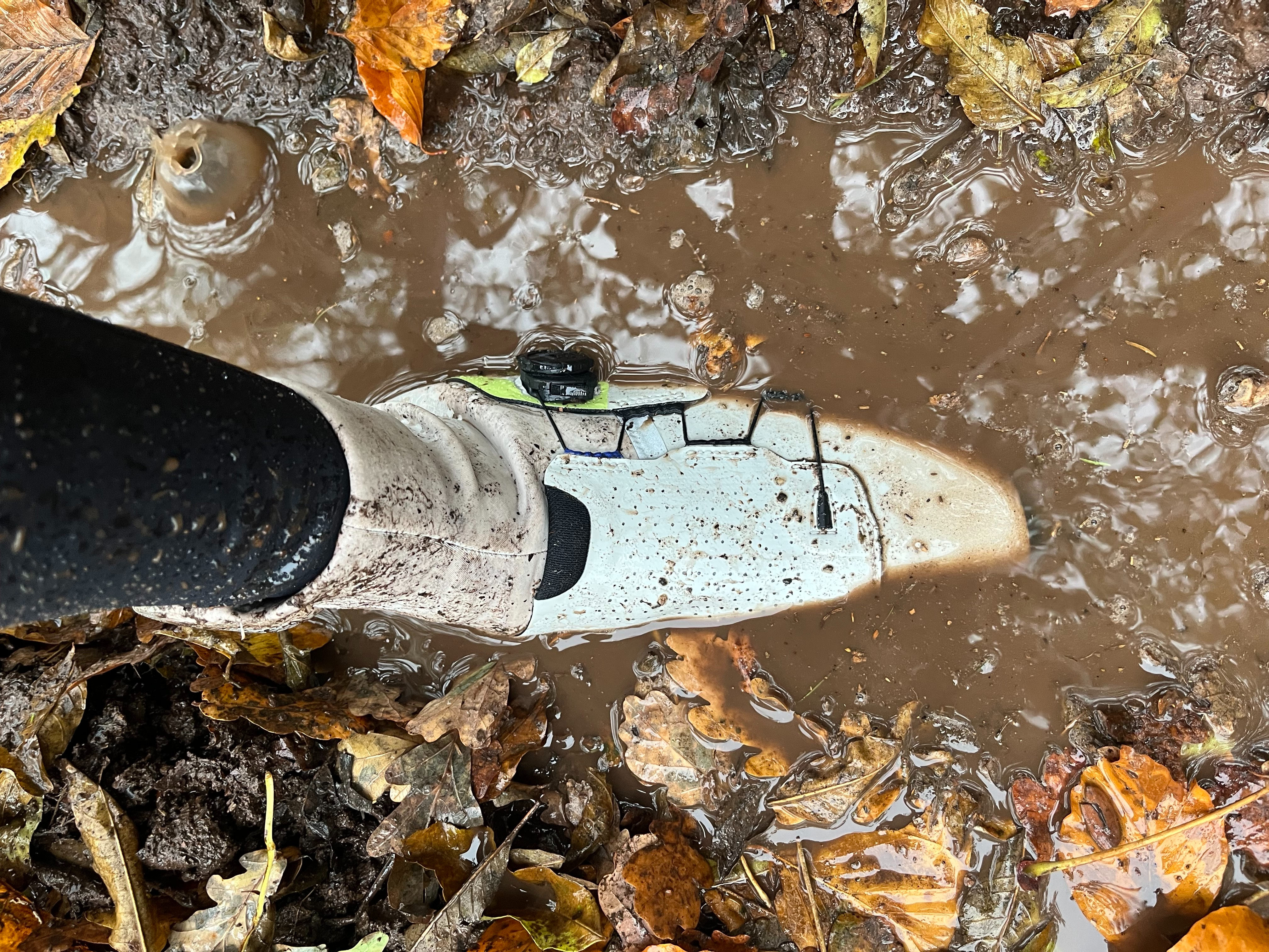 A Northwave gravel shoe submerged in mud 