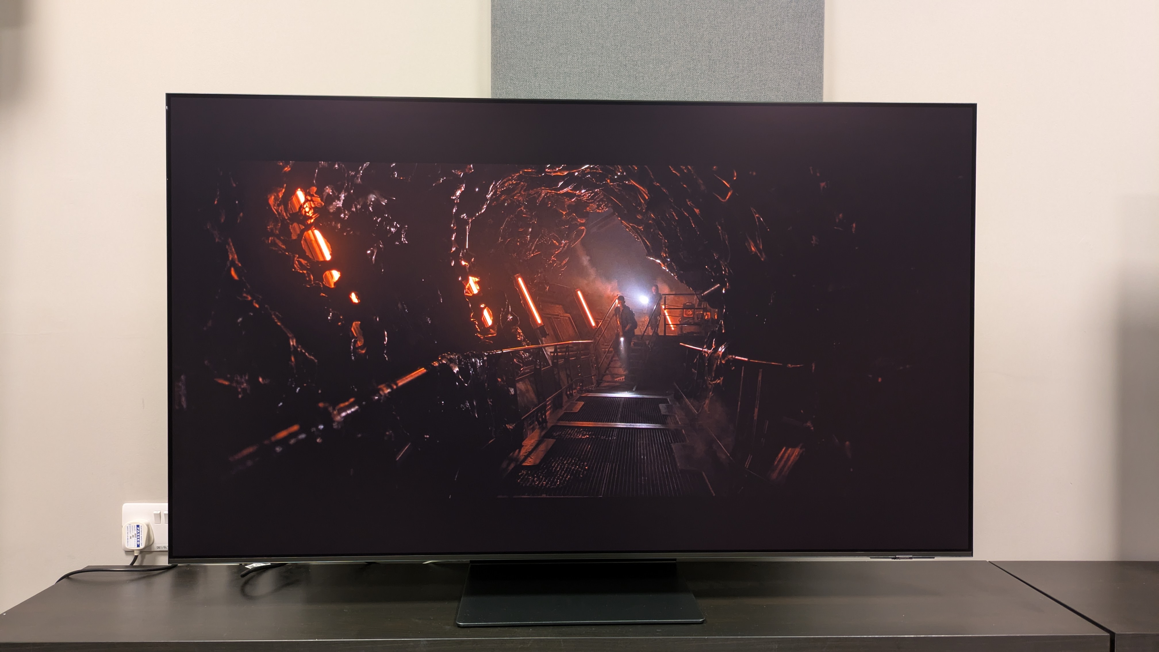 Samsung S95F in Filmmaker mode with Alien: Romulus orange-lit corridor scene on screen