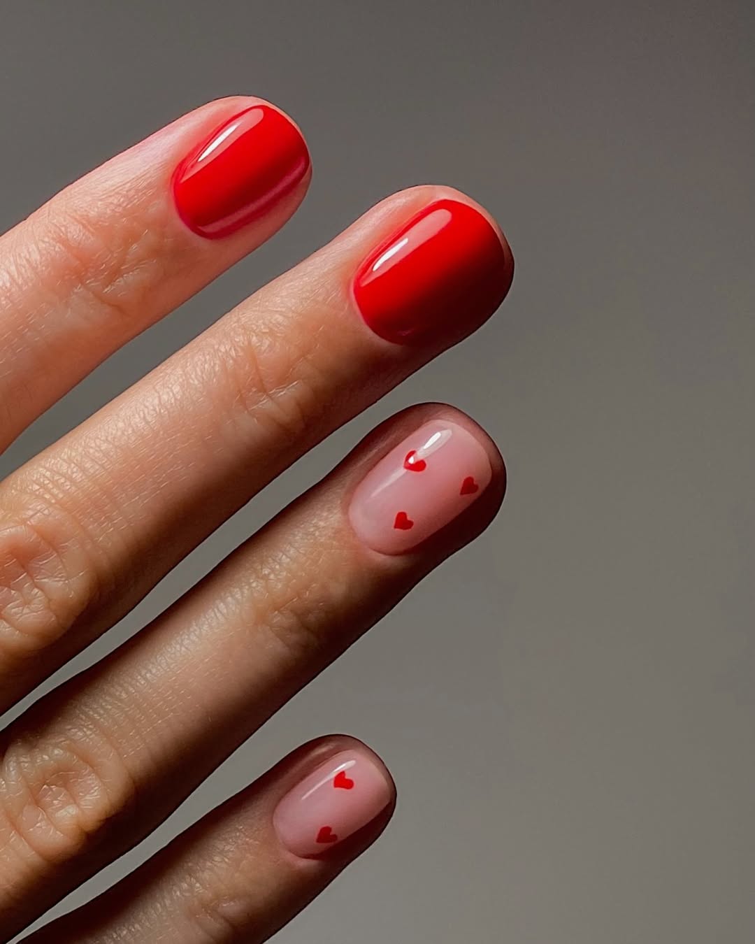 A bright red manicure with small heart details by Mateja Novakovic