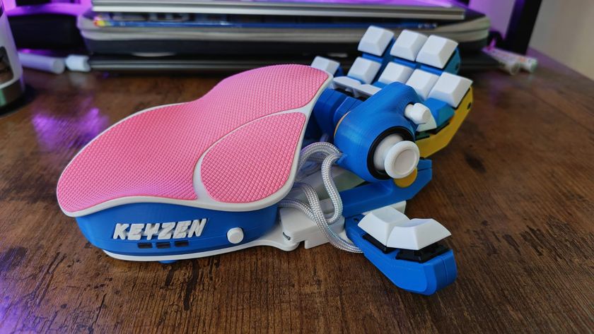 A blue, white, yellow, and pink Azeron Keyzen on a walnut desk surface