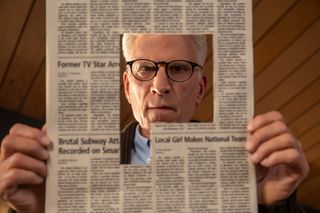 Ted Danson as Charles, looking down through a hole cut out of a newspaper, in episode 101 of 'A Man on the Inside.'