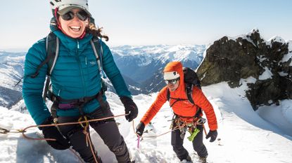 Two people wearing the Rab infinity microlight jacket on a snowy mountain