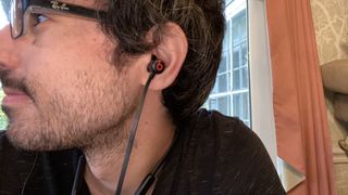 A close up of someone wearing the Beats Flex wireless earphones
