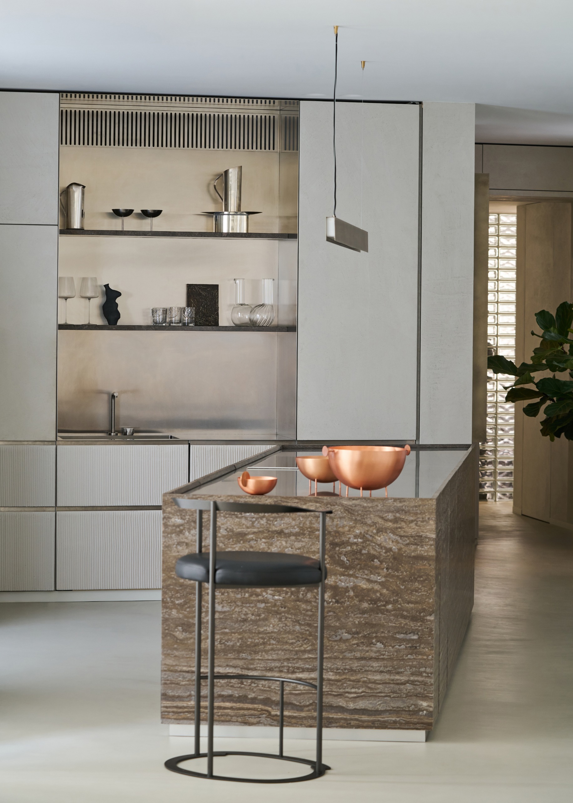 Sleek grey handleless kitchen with matt cabinetry, brown stone island and black bar stool