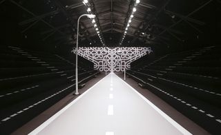 A runway styled like a road with a lamp post next to it and seating down both sides.