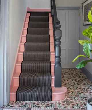 Pink stairs with black stair runner and encaustic traditional printed floor tiles