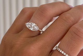 Woman wearing east-west set marquise engagement ring.